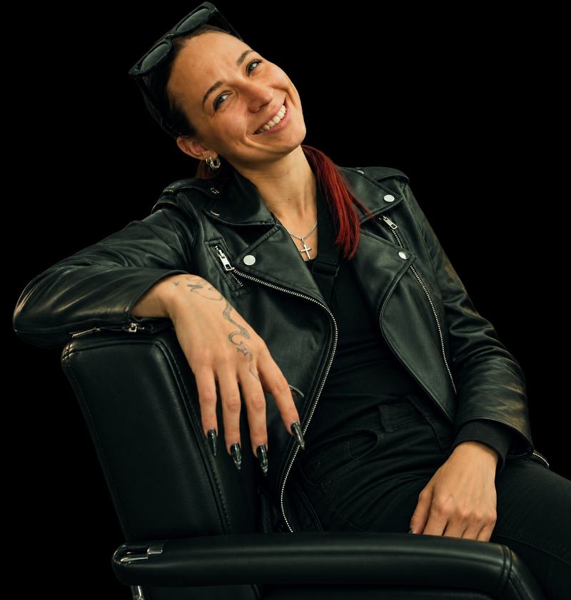 Lea, Gruenderin von CLAW CULT, in schwarzer Lederjacke auf einem Stuhl